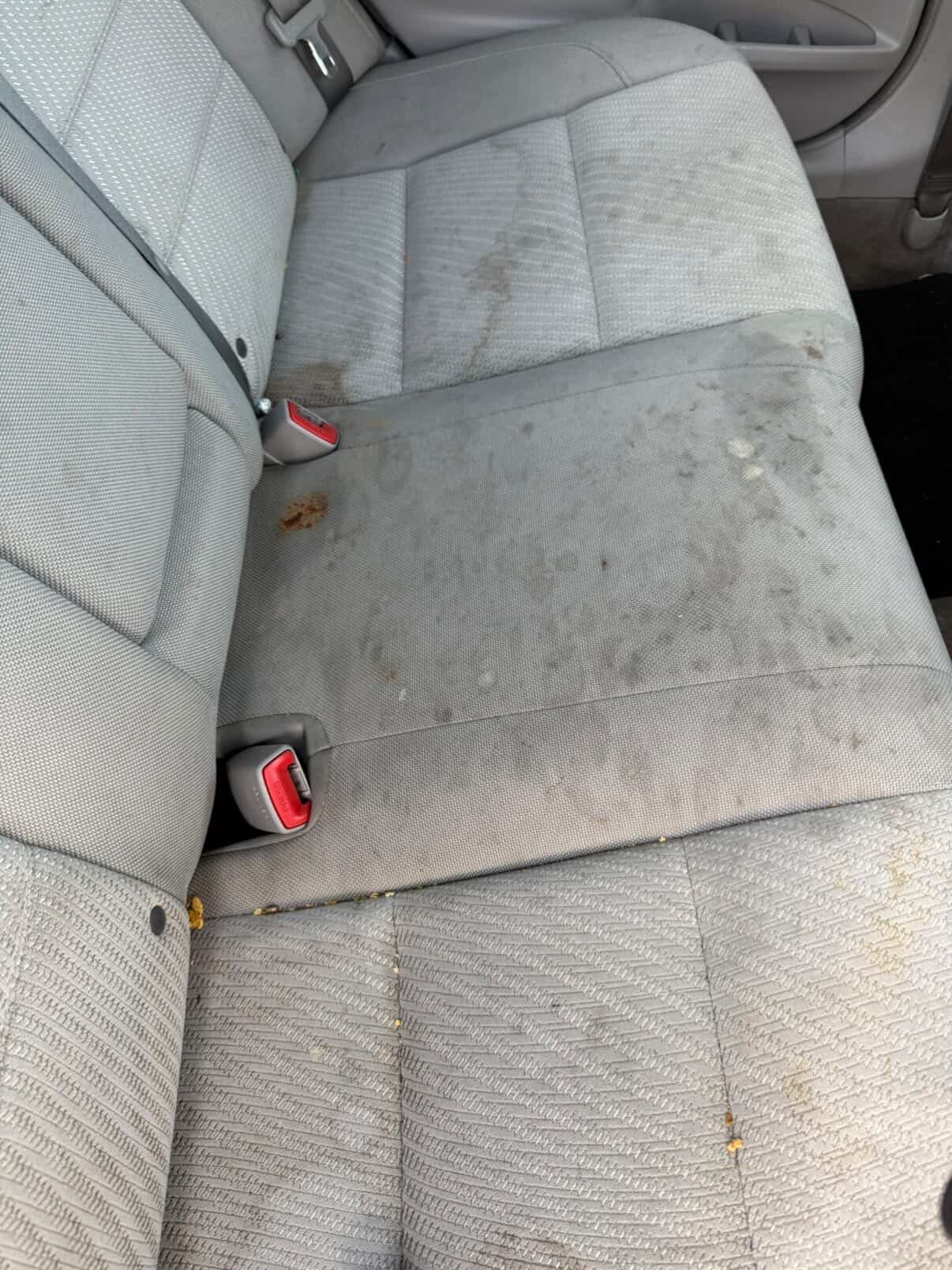 Heavily soiled gray cloth rear seats before deep cleaning