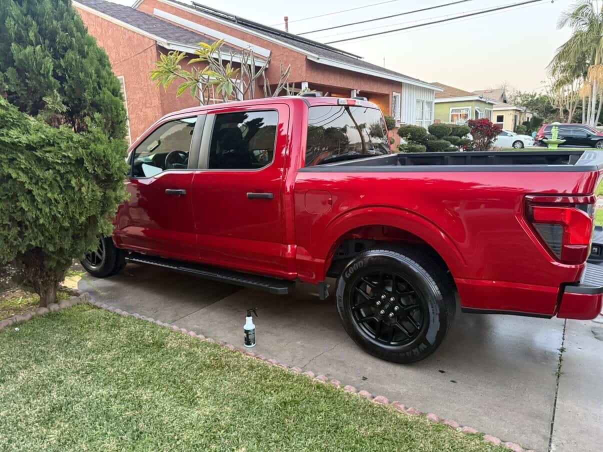 Red Ford F-150 detailed in driveway at golden hour