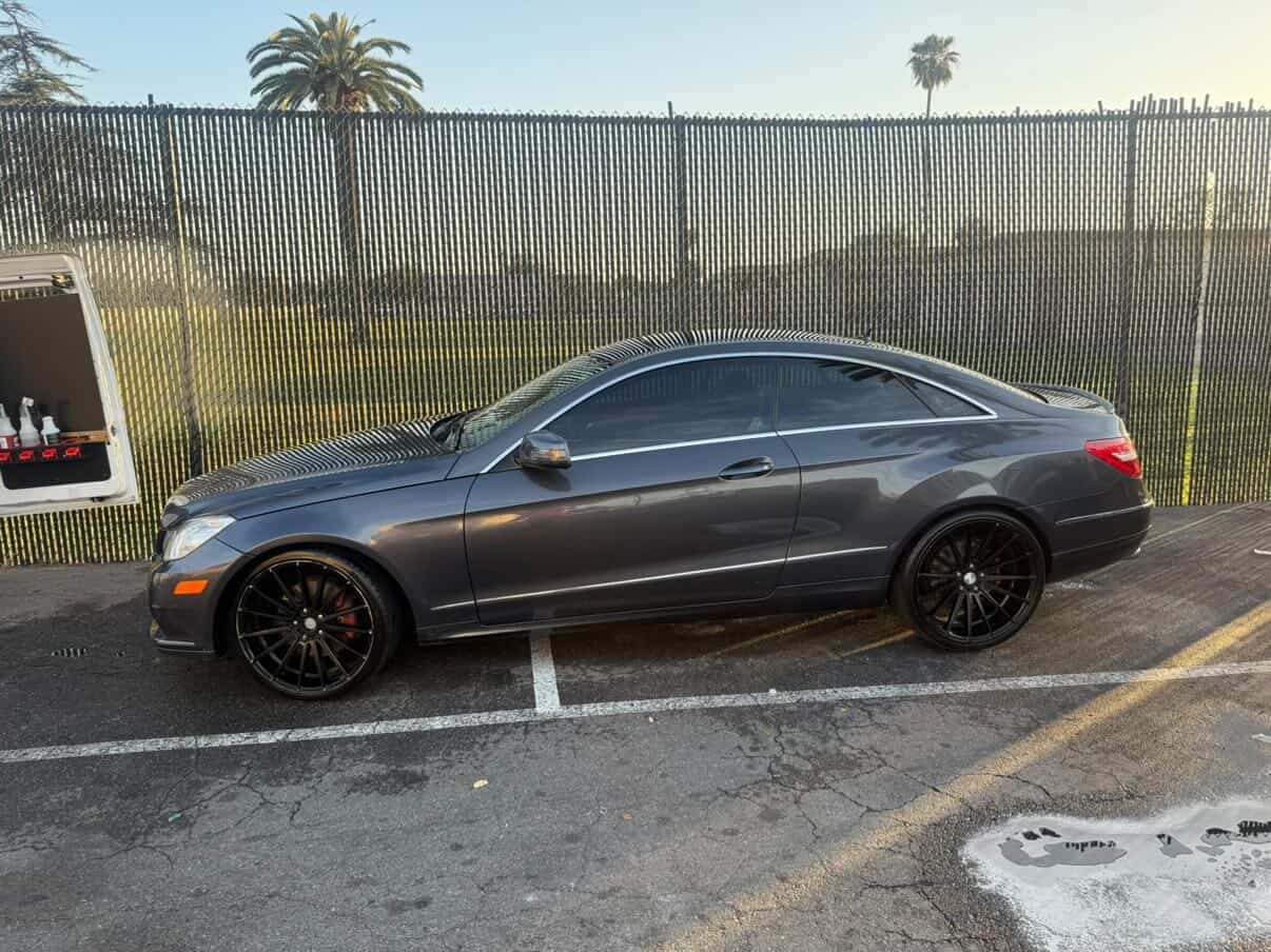 Gray Mercedes-Benz E-Class coupe with black wheels detailed at golden hour