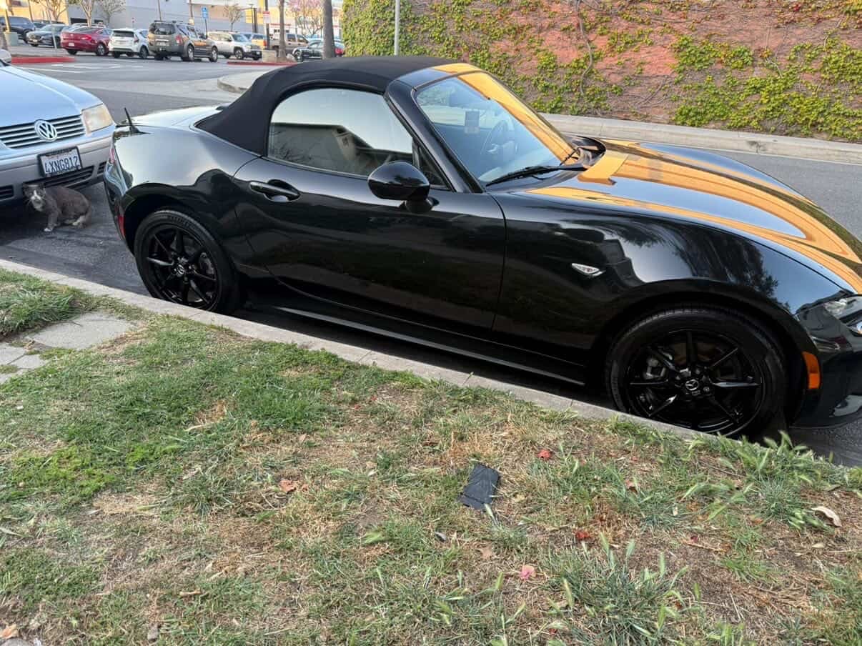 Black Mazda Miata convertible detailed curbside