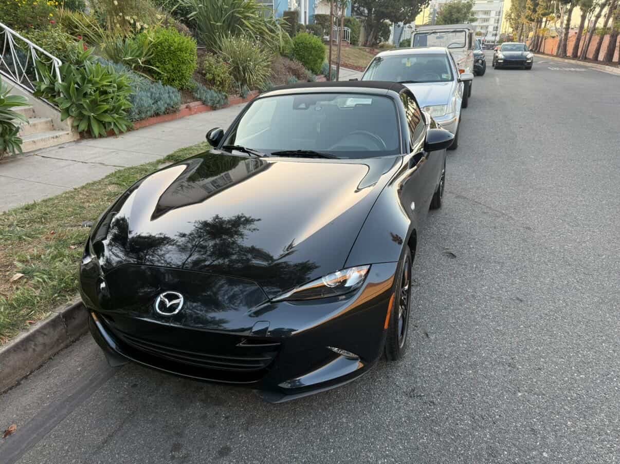 Black Mazda Miata convertible front view detailed curbside