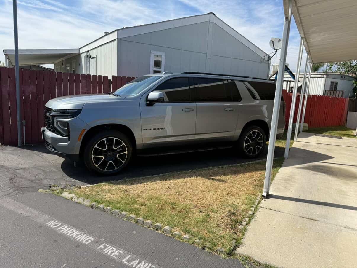 Silver Chevrolet Suburban detailed in carport