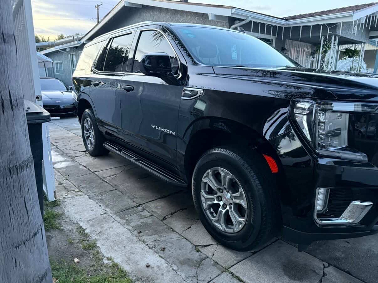 Black GMC Yukon detailed in driveway